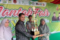 Plt. Kepala MAN 3 Aceh Besar Ismail, S.Pd.I., M.Ag., didampingi Pengawas Pembina Hj. Ratna Zaidah, S.Ag., M.Ed., menyerahkan Trophy Juara Umum MANTAB FAIR XVIII kepada Perwakilan MTs Oemar Dyan